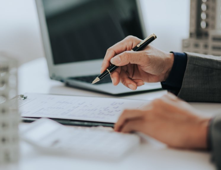 Claims advisor hand holding pen signing paperwork